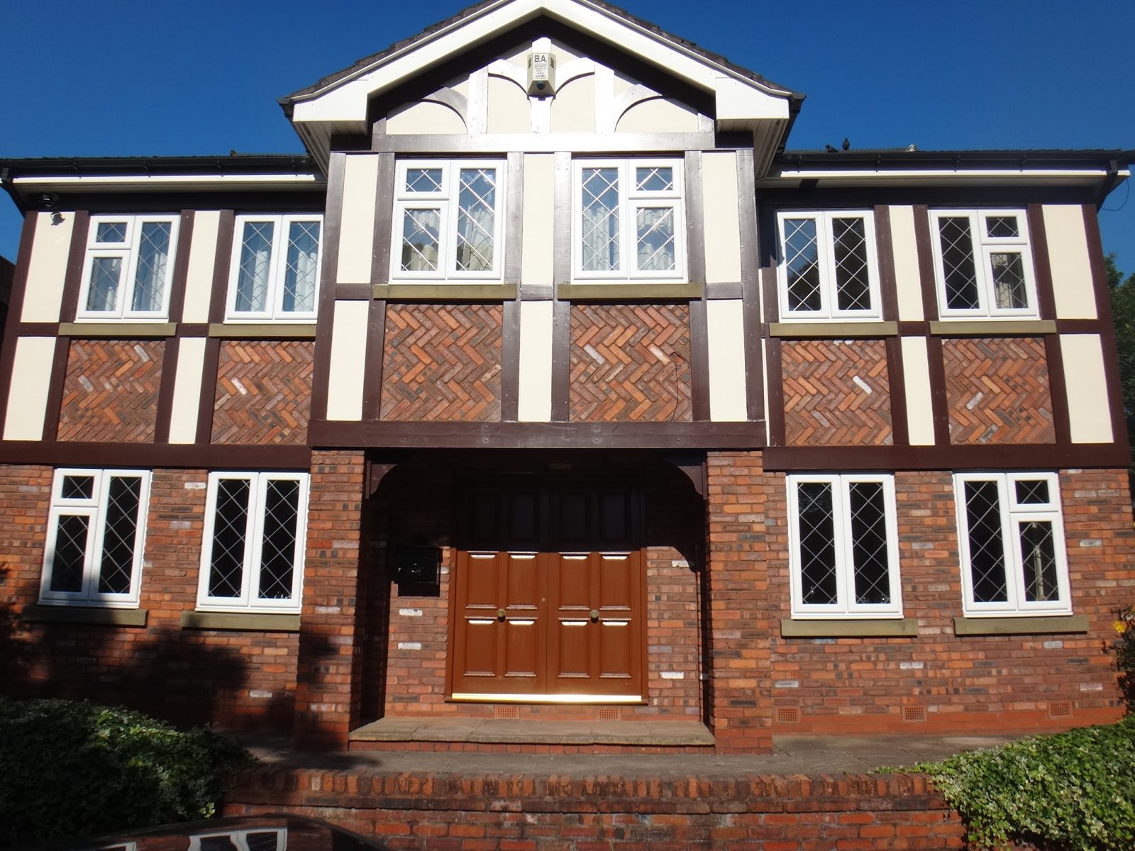 The front of a mock-Tudor house with painted timbers and front door