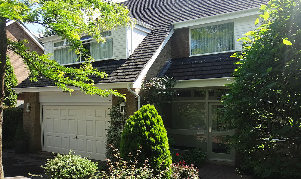 The outside of a detached house with its garage, freshly painted
